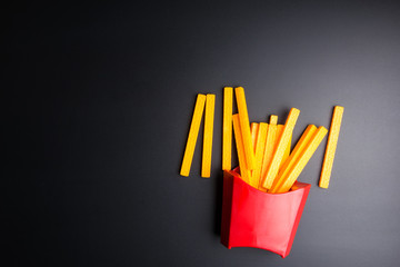 Toys French fries in red package on blabk background.
