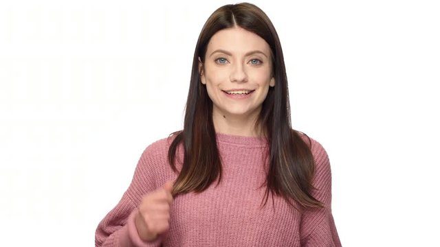 Portrait of cheerful adult woman 30s in gesturing index finger on camera meaning hey you, over white background. Concept of emotions