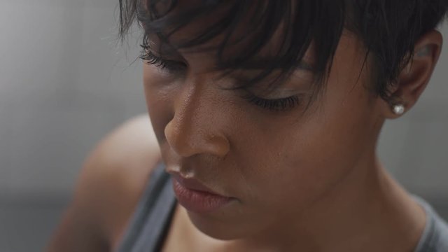 closeup mixed race woman portrait during a rest in fitness workout looking at camera and deep breathing