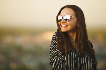 portrait of a young smiling girl in sunglasses with reflective glasses.