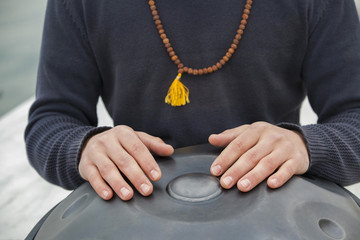 Man' s hands playing hang drum