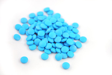Bright blue tablets close-up on white background