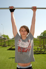 Fototapeta premium Boy hanging at outdoor gym