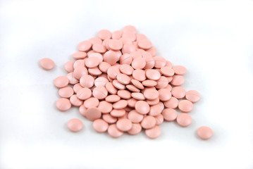 Rose round tablets close-up on white background