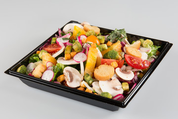 Salad in takeaway container on white background