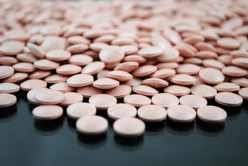 Light rose round tablets close-up on black background