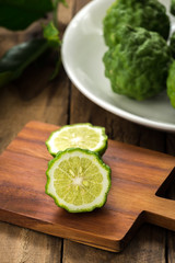 Kaffir lime or lime with white plate on wood


