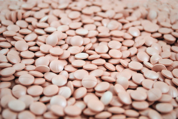 Light pink tablets closeup on white background