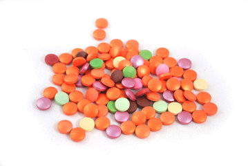 Multicolored round tablets closeup on white background