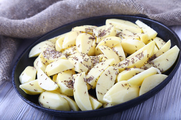 Tasty Crude Potato with caraway seeds in frying pan.
