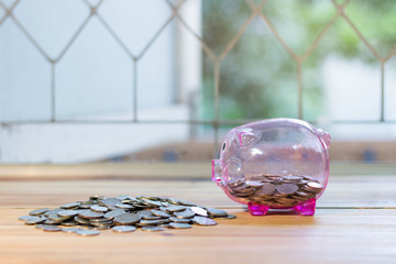 Pink piggy bank with a medal placed in front pile. , The concept of saving money for the future