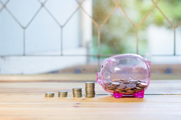 Pink piggy bank with a medal placed in front pile. , The concept of saving money for the future