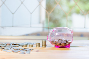 Pink piggy bank with a medal placed in front pile. , The concept of saving money for the future
