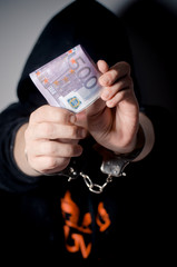 Hands in handcuffs that keeps euro bills. Bribe. Corruption. Place for text.