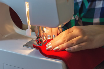 Woman sews red christmas sock
