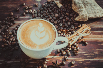 A cup of latte coffee and coffee beans. Toning.