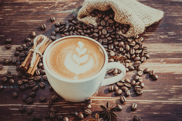 A cup of latte coffee and coffee beans. Toning.