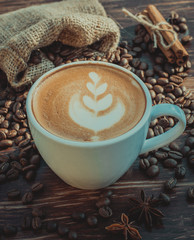 A cup of latte coffee and coffee beans. Toning.