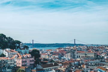 Fototapeta na wymiar Lisbon. Bridge and Jesus Christ in background. Rooftops. Sunny spring day.