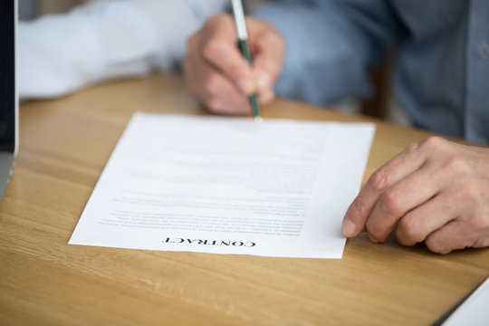 Older male hand signing business contract, senior man putting signature on document legal paper agreeing to make investment, elderly aged businessman taking bank loan or insurance, close up view