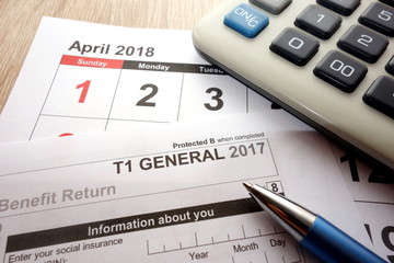 Canadian T1 form and April calendar on desk, tax season 2018 in Canada concept