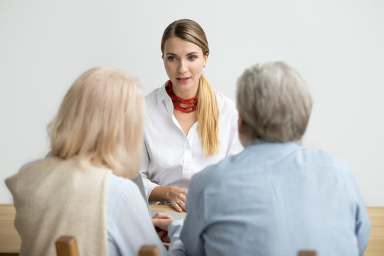 Female Financial Advisor Consulting Senior Couple About Making Investment, Insurance Broker, Realtor Or Travel Agent Talking To Older Family Presenting New Offer At Meeting, Woman At Job Interview