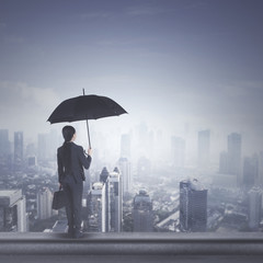 Young business woman with umbrella on rooftop