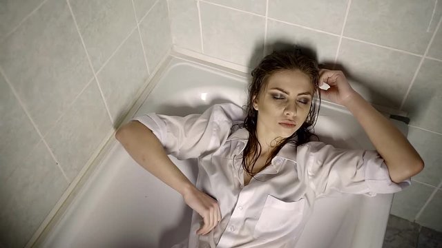 Lying in a bathtub wet woman