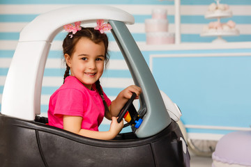little girl in a toy car