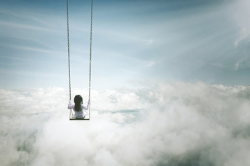 Lonely girl sitting on the swing above clouds - obrazy, fototapety, plakaty