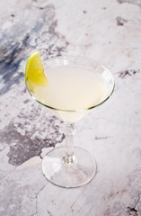 perfect classic margarita, white alcoholic cocktail with decoration of salt on the edge of the glass with lime, lemon, daiquiri on gray background restaurant. Bar alcohol menu, sweet drink.