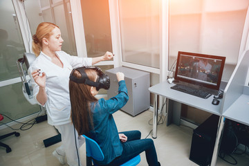 Ophthalmology doctor checks the girl's vision with the help of virtual reality goggles.