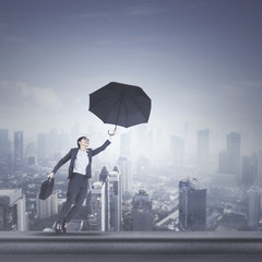 Fototapeta premium Beautiful manager with umbrella on rooftop