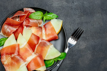 italian food with melon and prosciutto on the plate