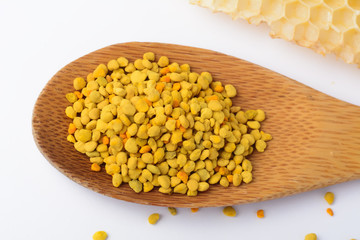 Bee pollen in a wooden spoon and a honeycomb. Beekeeping products. Apitherapy.