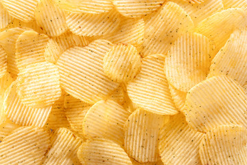 Potato chips background in the sunlight. Closeup.