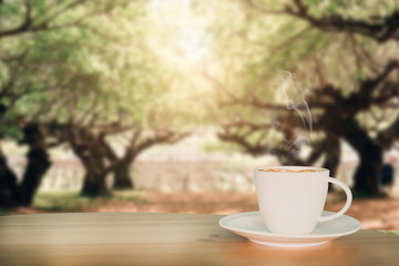 Coffee espresso on wood table nature background in garden,warm tone