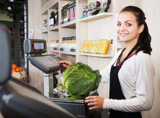 Female seller weighing cabbage