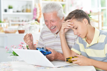 portrait of  boy and  grandfather playing computer game 