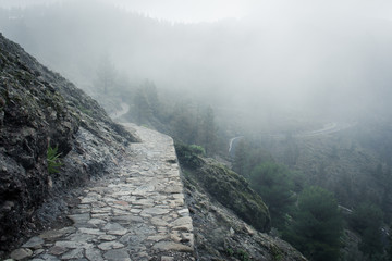Empty rock path on dense misty day in Roque Nublo natural park, Gran Canaria. Mysterious walkway...