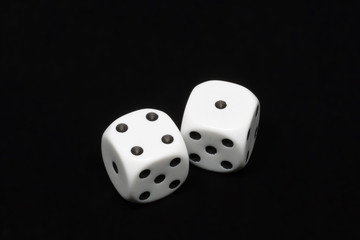 The dices are cast - two dices showing four and one for a total of five on an isolated black background