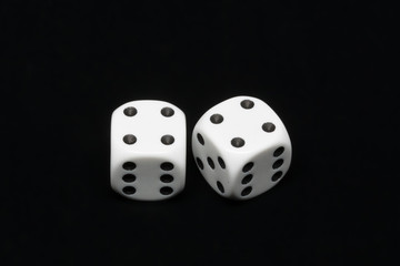 The dices are cast - two dices on a black background showing a total of eight eyes 