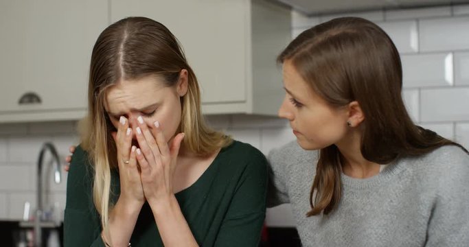 4K Young woman upset about a problem & her caring friend giving her support. Slow motion.