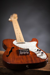 Vintage electric guitar on a wood raw table. Musical instrument. Black background with smoke