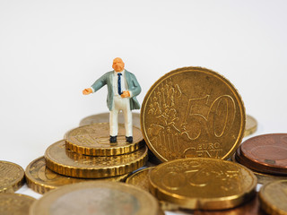 Miniature businessman stand on Euro coins and book bank. Business and idea concept.