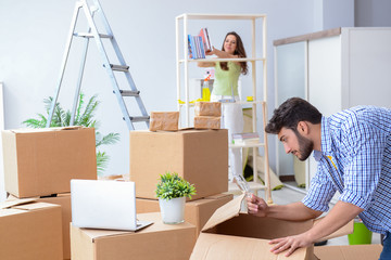 Young family unpacking at new house with boxes
