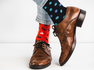 Male legs in bright, colorful socks and stylish, vintage shoes on a white background. Lifestyle,...