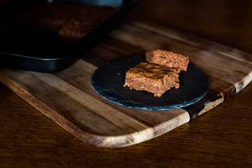 Saftiger Kuchen aus Zartbitterschokolade mit Mandeln vom Blech angerichtet auf einer Schieferplatte