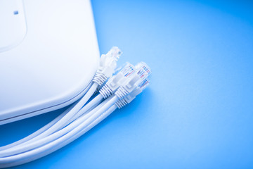 Corporate network concept. Set of ethernet switches, access points, cables, connectors, laptops on the blue background. Top view. Space for a text. Close up.