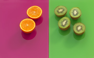 kiwi and orange fruits on green-purple glass background